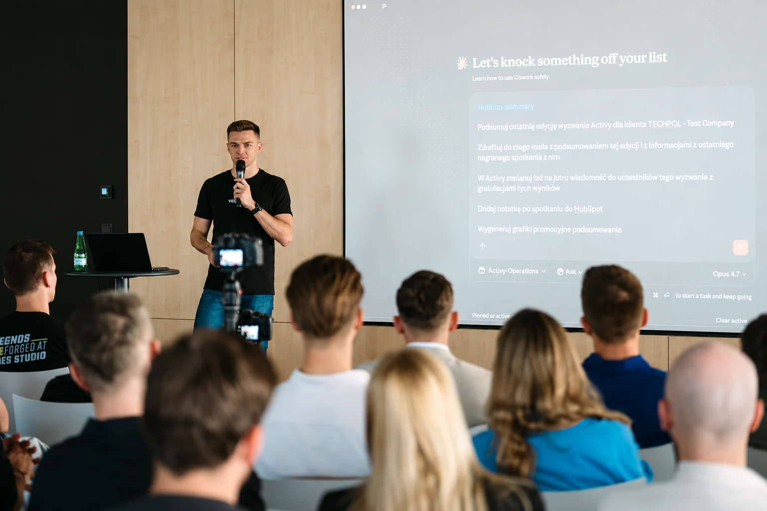 Igor Pielas showing practical uses of AI at Aula Polska, a tech event in Warsaw, with his slides and the audience in view.